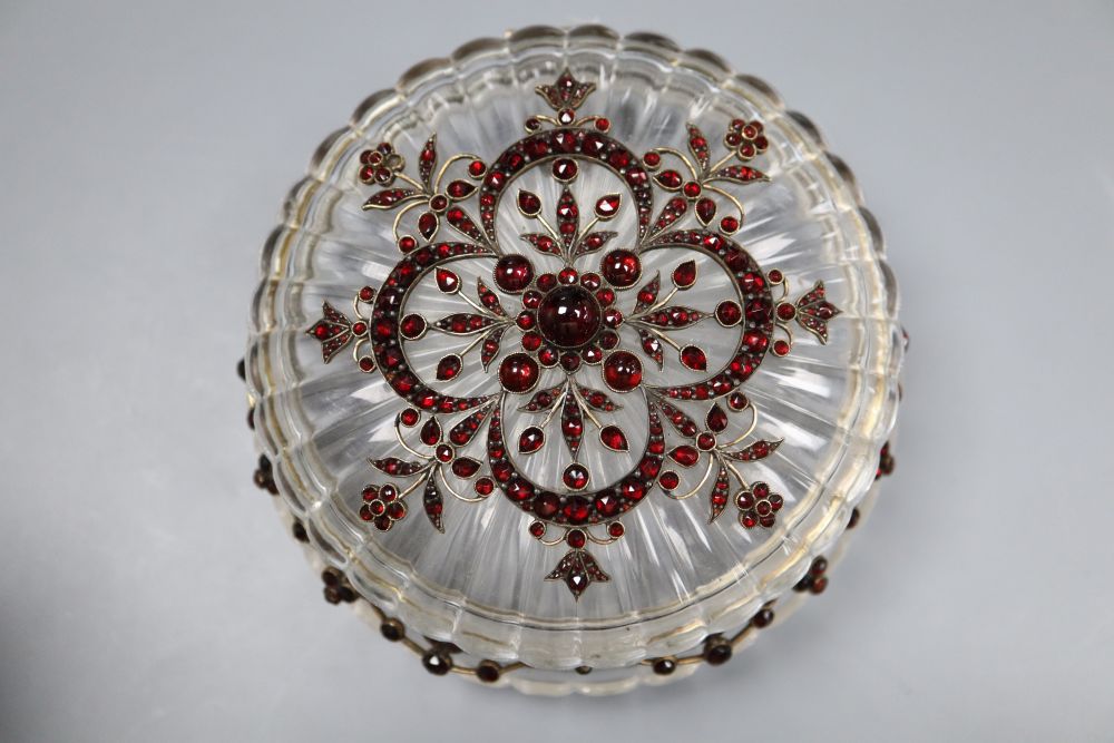 A Victorian yellow metal, cabochon and facet cut garnet mounted circular fluted glass powder jar, diameter 10.7cm.